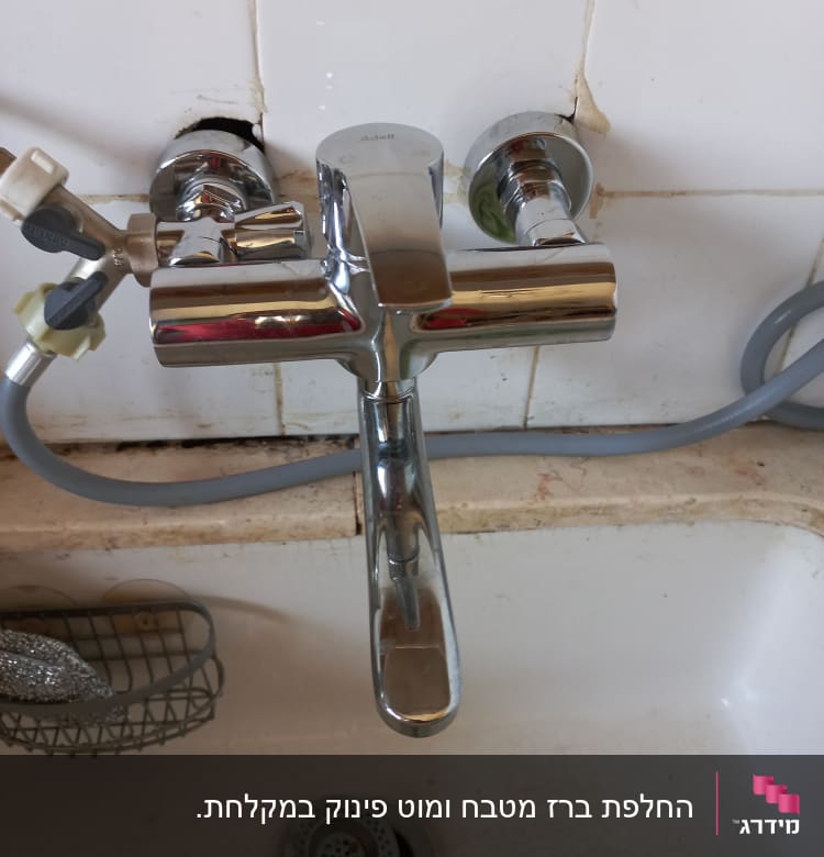 ברז כרום מותקן על קיר עם צינור מחובר